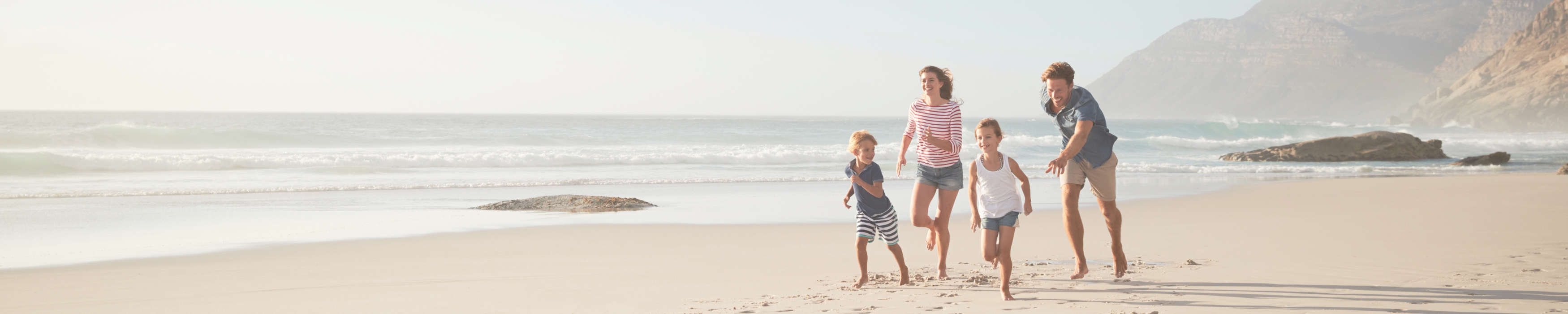A family running along the beach together